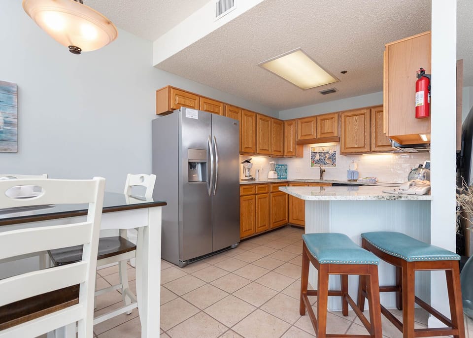 Prepare meals in the spacious kitchen featuring ample cabinetry, stainless appliances, and a stylish breakfast bar