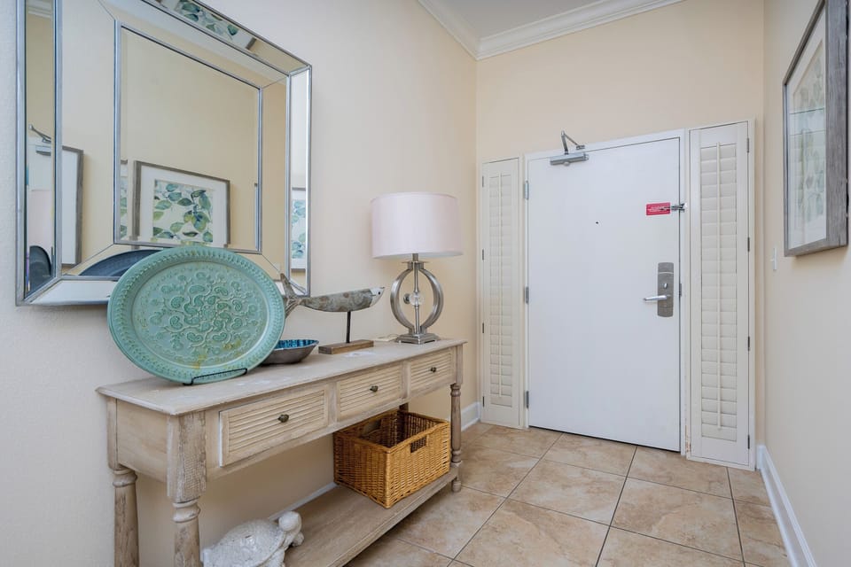 This welcoming entryway features a stylish console table, decorative accents, and a soft lamp, creating a warm impression