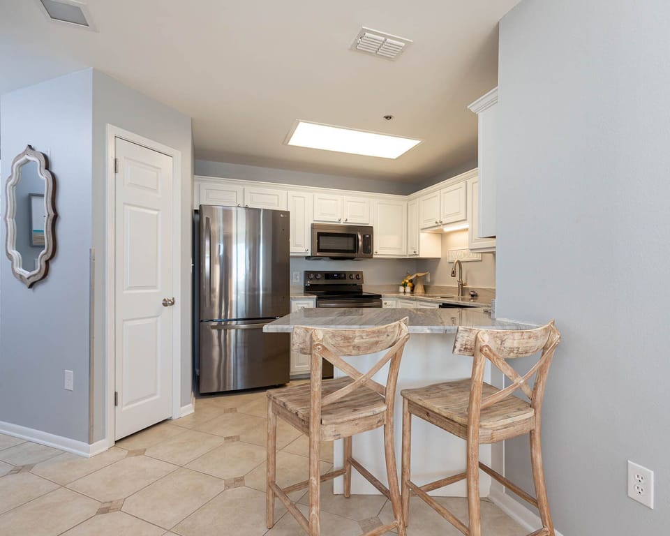Prepare meals in the stylish kitchen featuring stainless appliances and a breakfast bar with rustic seating