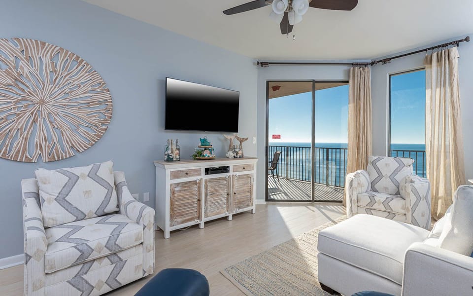Relax in the inviting living area featuring a sofa with queen sleeper and a beach view that opens to the balcony