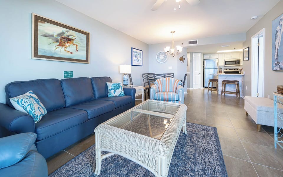Unwind in the inviting living area, featuring a comfortable sofa with queen sleeper, stylish decor, and a glass coffee table