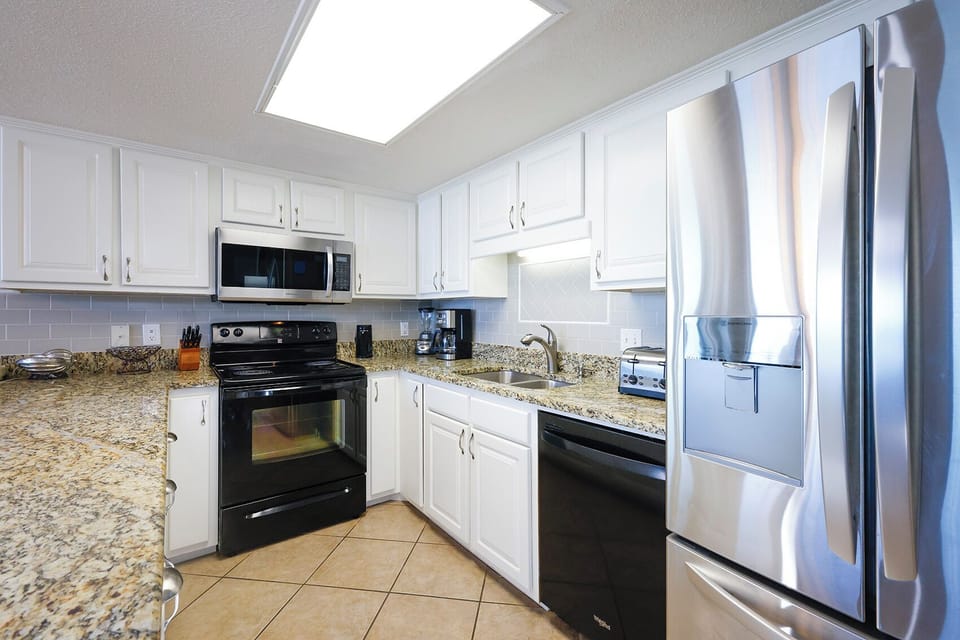 Prepare meals in this stylish kitchen featuring granite countertops and white cabinetry
