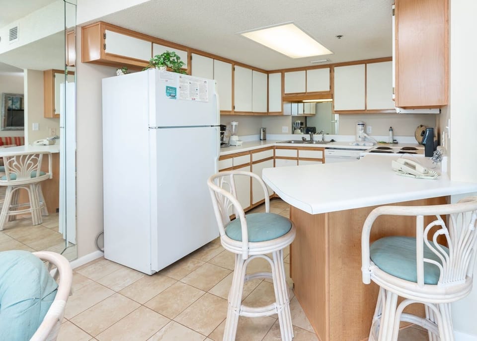 Bright and airy kitchen features white cabinetry, a breakfast bar with seating, and a breakfast bar area for convenience