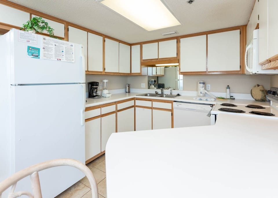 The fully-equipped kitchen features white cabinetry, a breakfast bar, and essential appliances for convenient meal prep