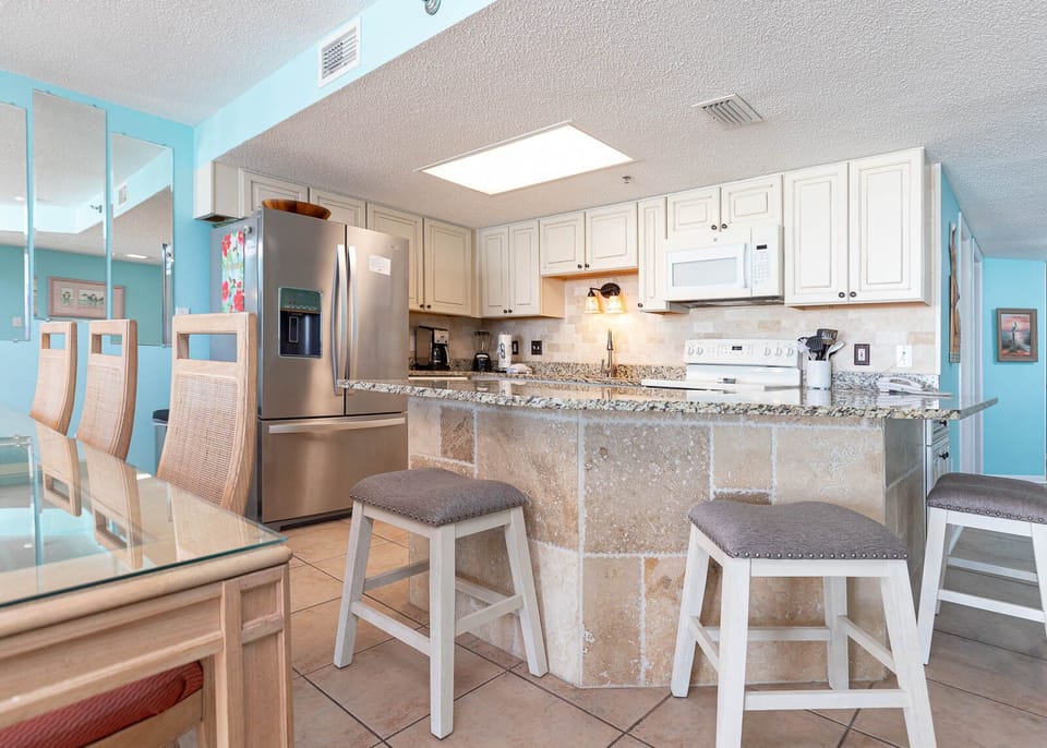 Kitchen area featuring granite countertops, a breakfast bar, and modern appliances for a delightful cooking experience