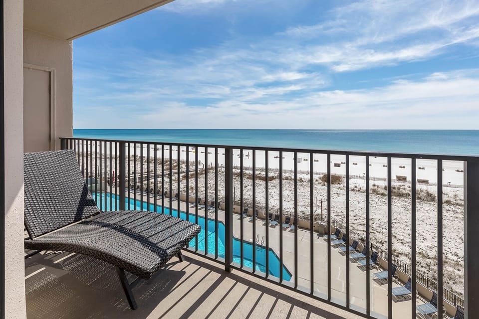 Relax on the balcony lounge chair, enjoying views of the pool and the tranquil waters beyond