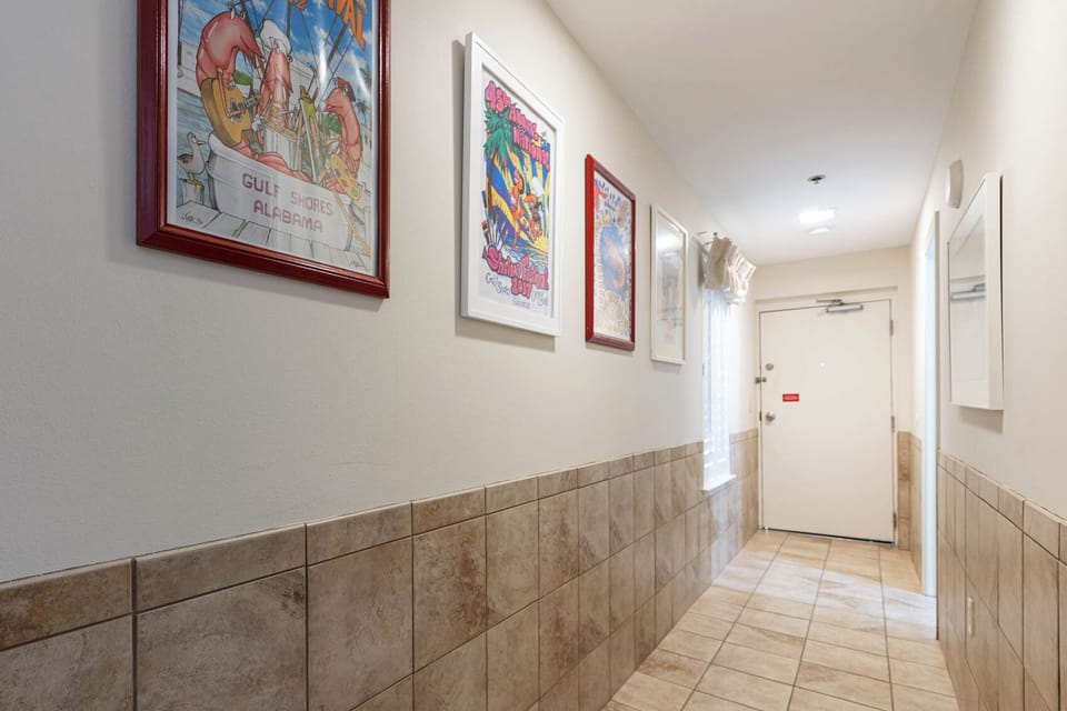 Walk down a charming hallway adorned with colorful artwork, leading to your inviting vacation retreat