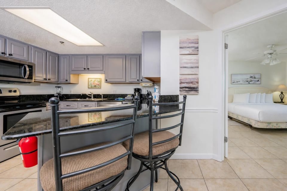 Modern kitchen with granite countertops, a breakfast bar with seating, and stainless appliances