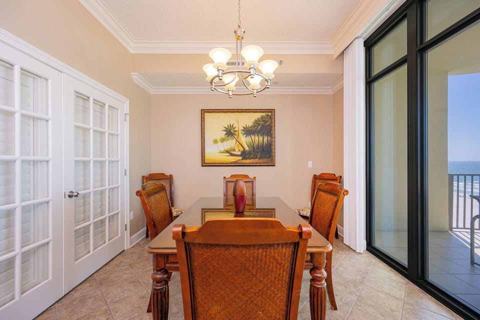Gather around the dining table as the sun casts a warm glow through the glass doors