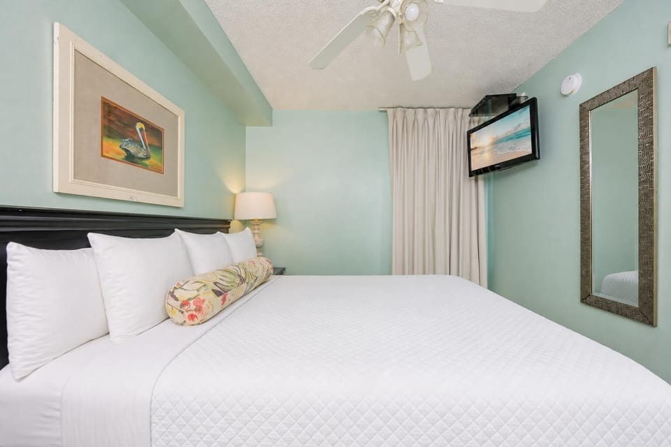 Fluffy pillows invite you to relax in the king suite for a calm movie night after a fun day at the beach