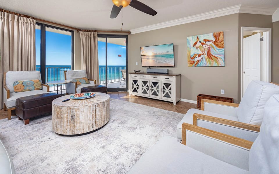 Relax in the airy living area featuring a sofa with queen sleeper, large TV, and stunning beach views