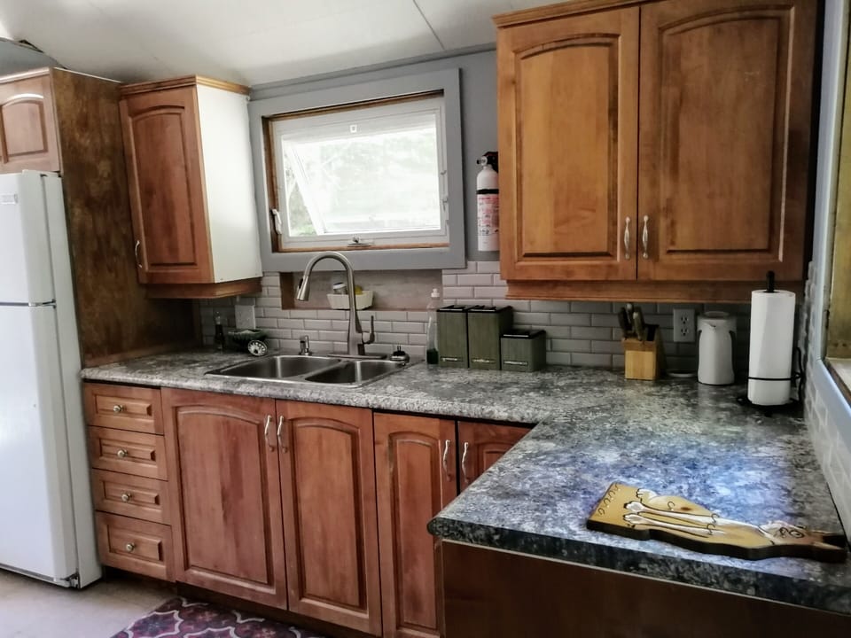 Renovated Kitchen with new laminate countertops, sink, and faucet  