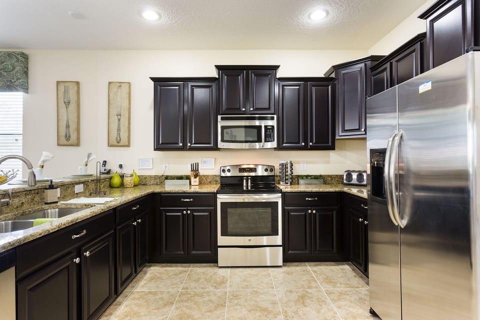 The fully-equipped kitchen features stainless steel appliances and granite countertop