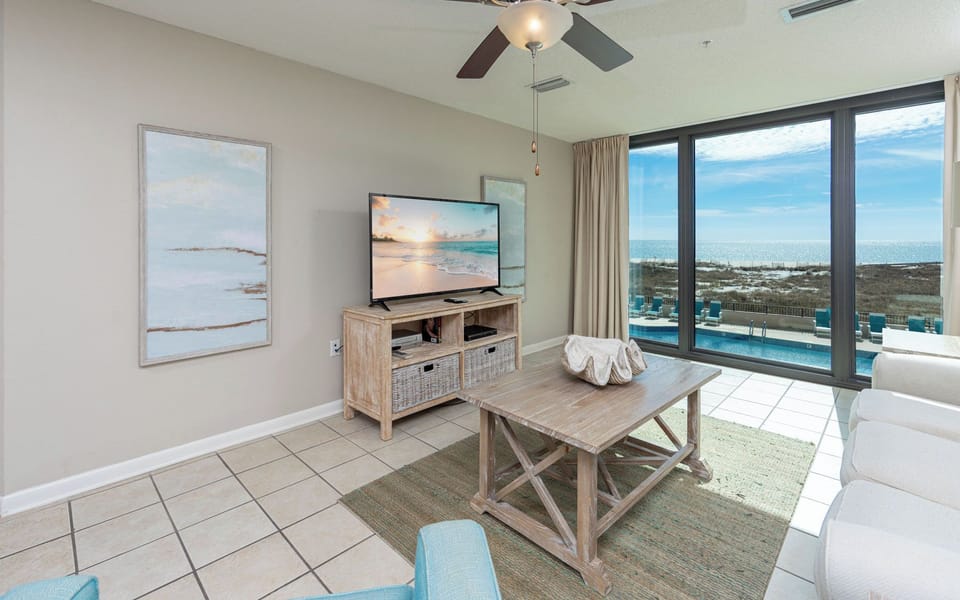 Enjoy the spacious living area with a large TV, inviting decor, and stunning views through expansive windows