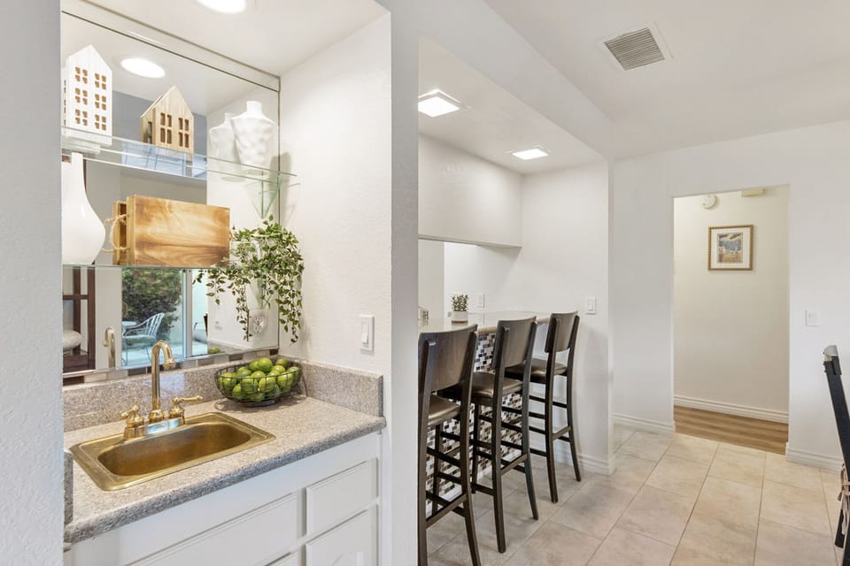 Wet bar(not functional) and seating for three between kitchen and dining table