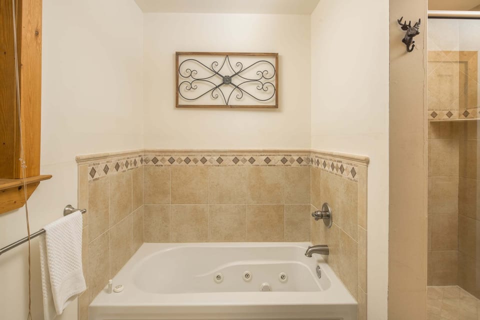 Private ensuite bathroom featuring a soaking tub and separate walk-in shower