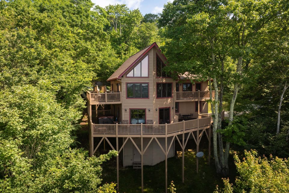 Exterior view of the three-story mountain cabin surrounded by trees in a private gated community near Banner Elk