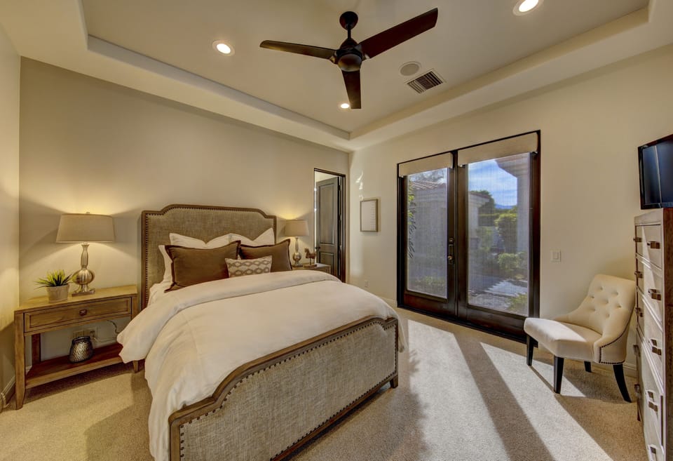 Guest bedroom 2 with queen bed, en suite bath, TV and direct access to front private courtyard.