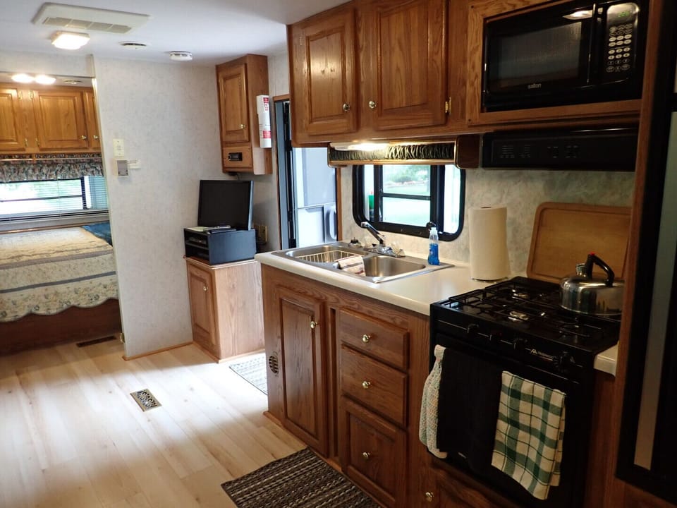 Fully equipped kitchen with stove, oven, microwave, fridge and small freezer.