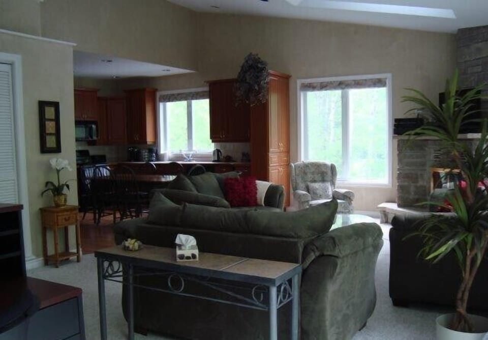 Great room with wood-burning stone fireplace, access to private deck; office area with WiFi and high-speed internet
