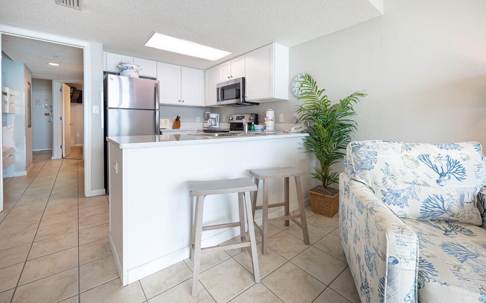 Enjoy cooking and dining at the breakfast bar, surrounded by a bright, inviting kitchen and coastal decor