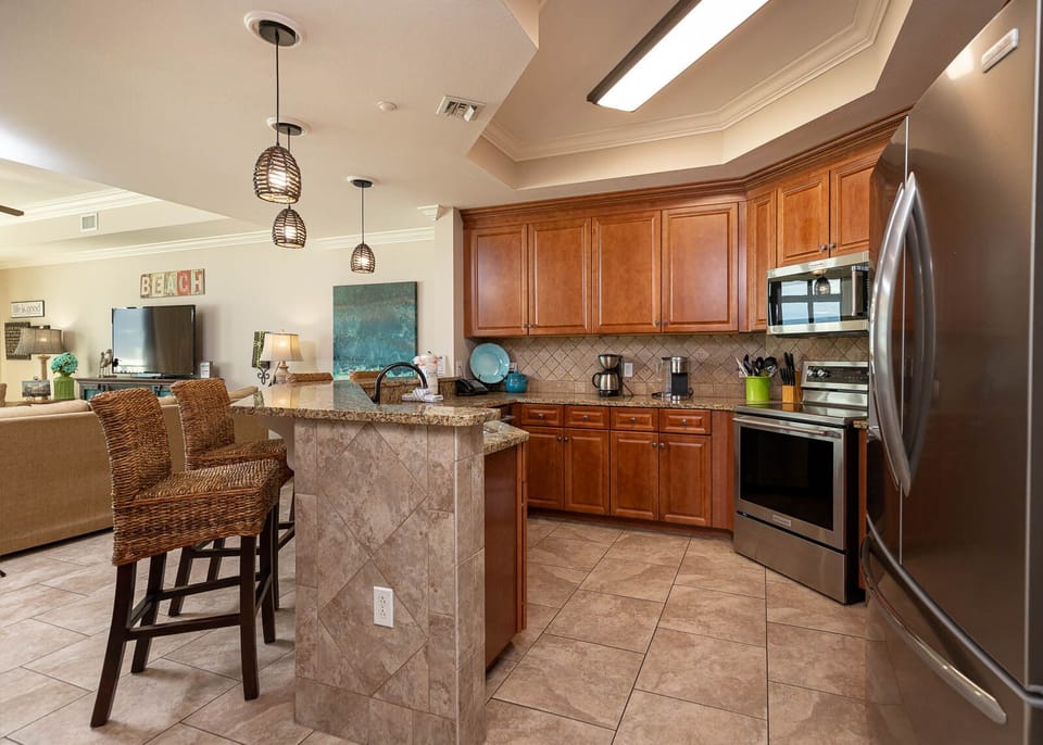 The kitchen features rich wood cabinetry, stainless appliances, and a cozy breakfast bar, perfect for enjoying morning coffee