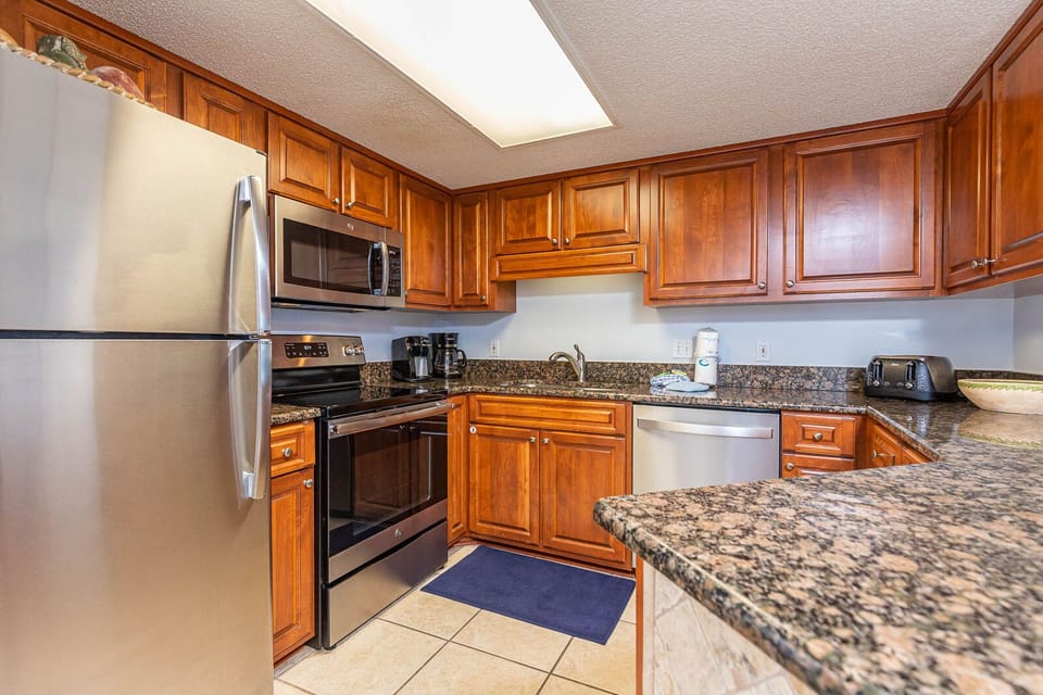 This modern kitchen features stainless appliances, granite countertops, a Keurig and coffee maker, and welcoming vibe