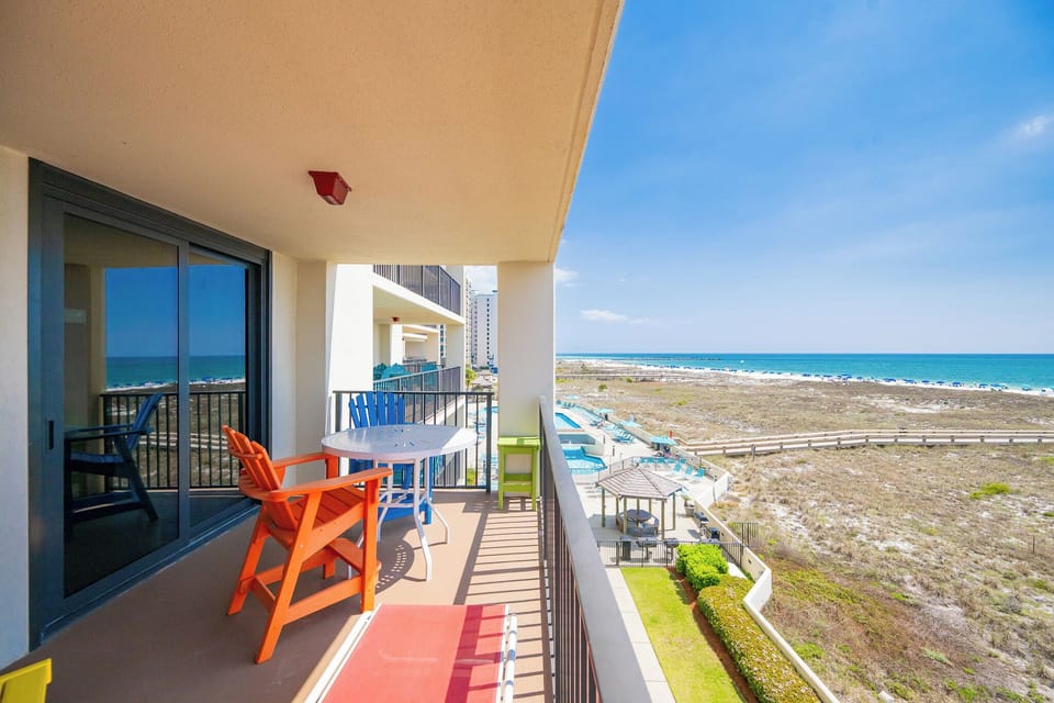 Relax on your balcony in colorful chairs, savoring the coastal views and gentle breezes of beach life