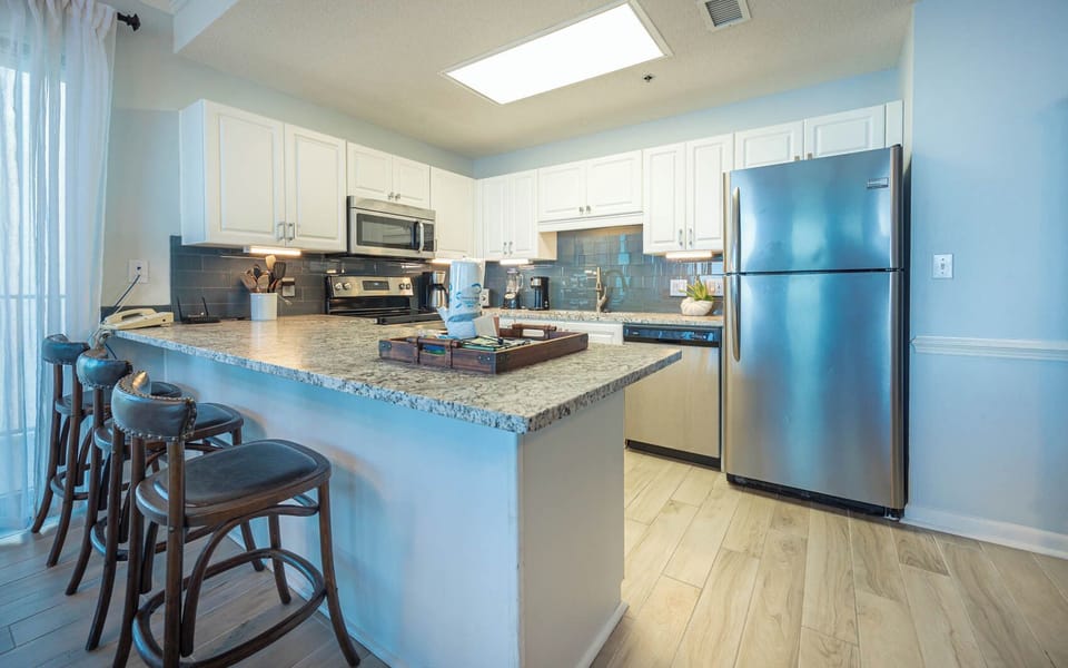 Cook and gather at the spacious kitchen bar with stylish stools and stainless appliances for a delightful meal experience