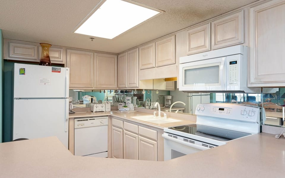Kitchen features light cabinetry, a spacious countertop, and essential appliances, perfect for meal preparation
