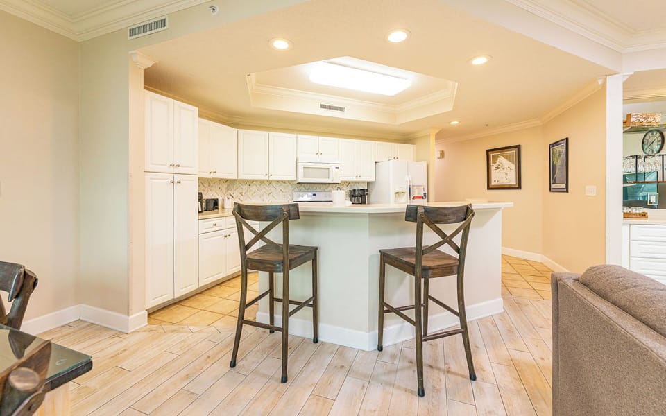 Enjoy morning coffee or casual dining at your breakfast bar with the kitchen's bright white cabinetry surrounding you