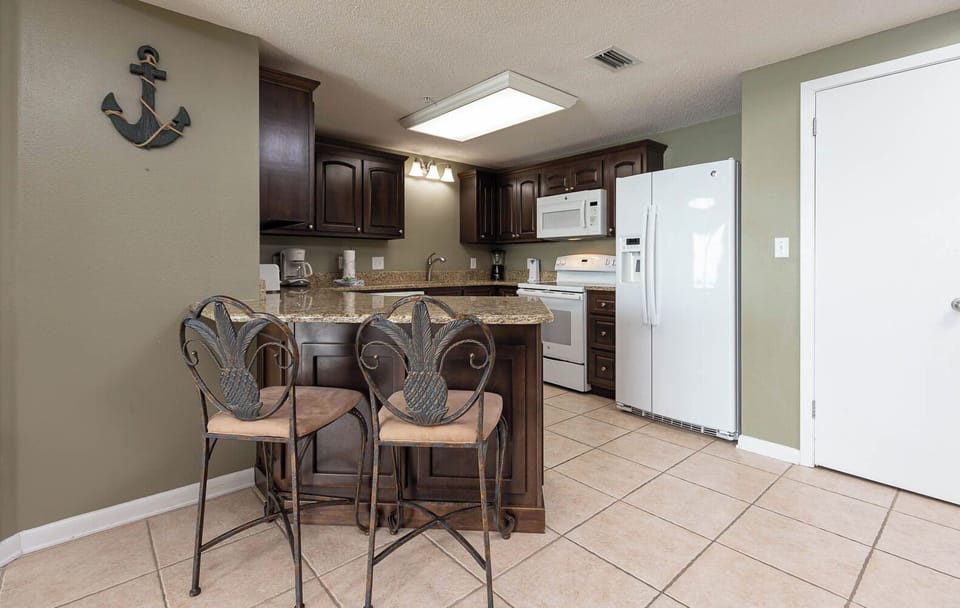 Gather around the stylish breakfast bar, perfect for enjoying meals or morning coffee in this inviting kitchen space