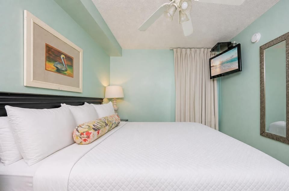 Fluffy pillows invite you to relax in the king suite for a calm movie night after a fun day at the beach