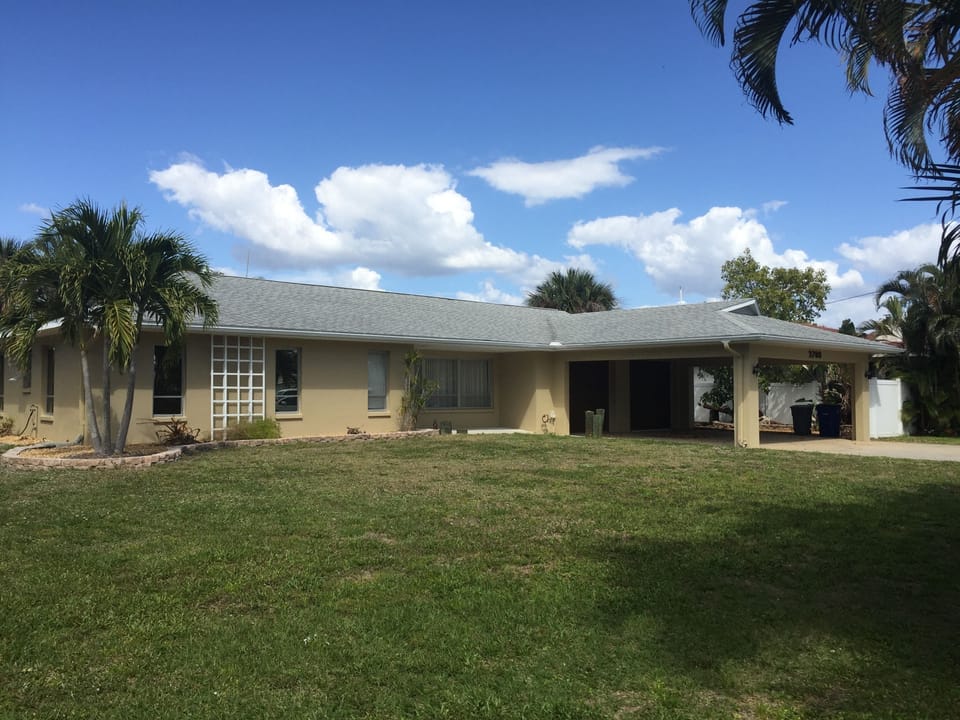 Front of the house, with a two car garage and a car port.