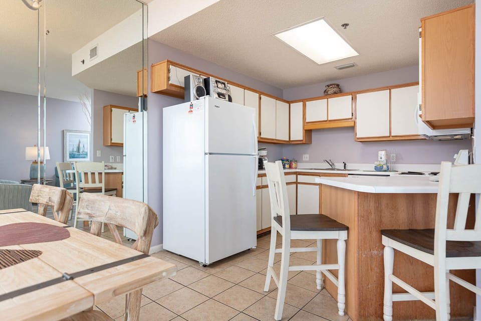 Bright kitchen area featuring white cabinetry, a breakfast bar with seating, and a view towards the dining space