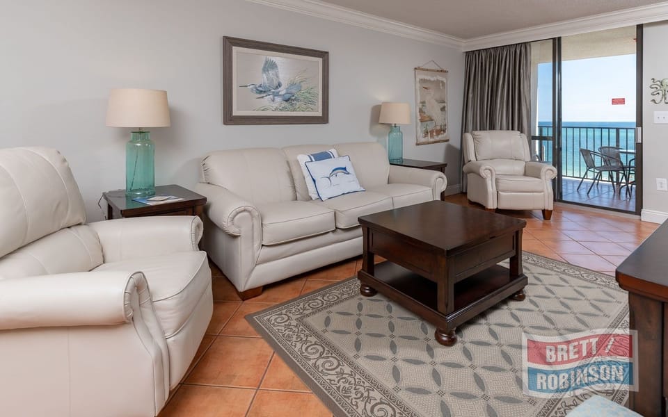 Relax in the inviting living area, featuring comfortable seating, queen sofa sleeper, and beachfront balcony access