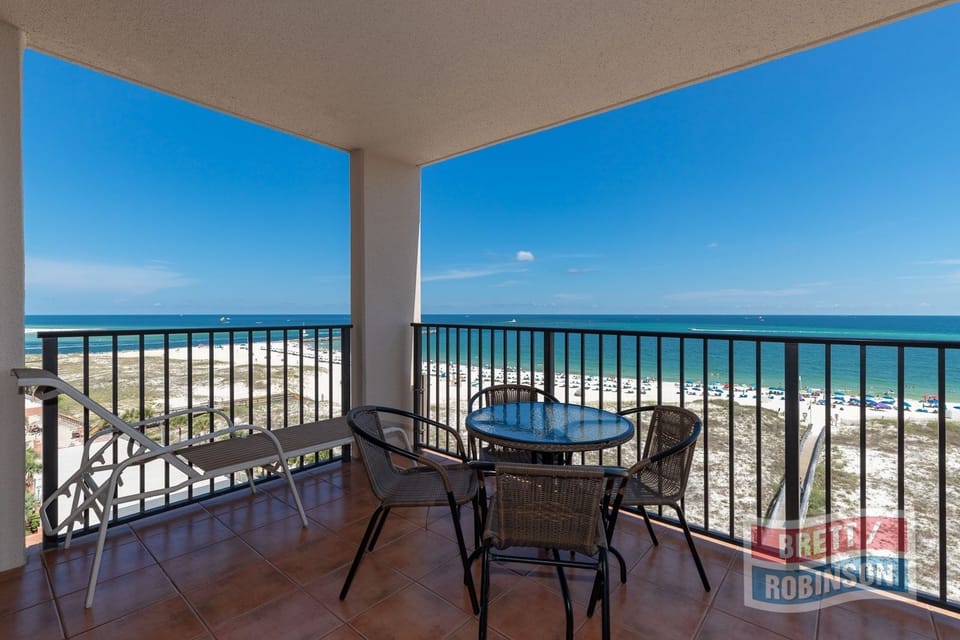 Relax on the balcony with comfortable seating and enjoy panoramic views of the coastline and inviting waters