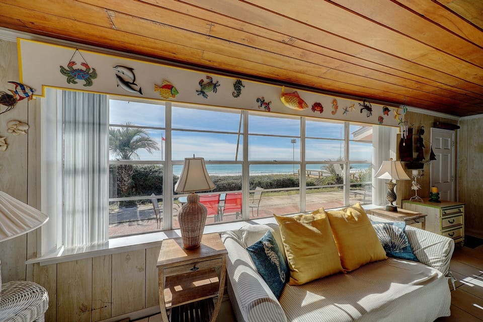 Sunshine floods the room as you look out over the white sands and blue water.
