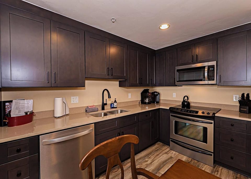 Open concept kitchen, dining and living area with gas fireplace, flat screen TV, pull-out sofa and views of the slope