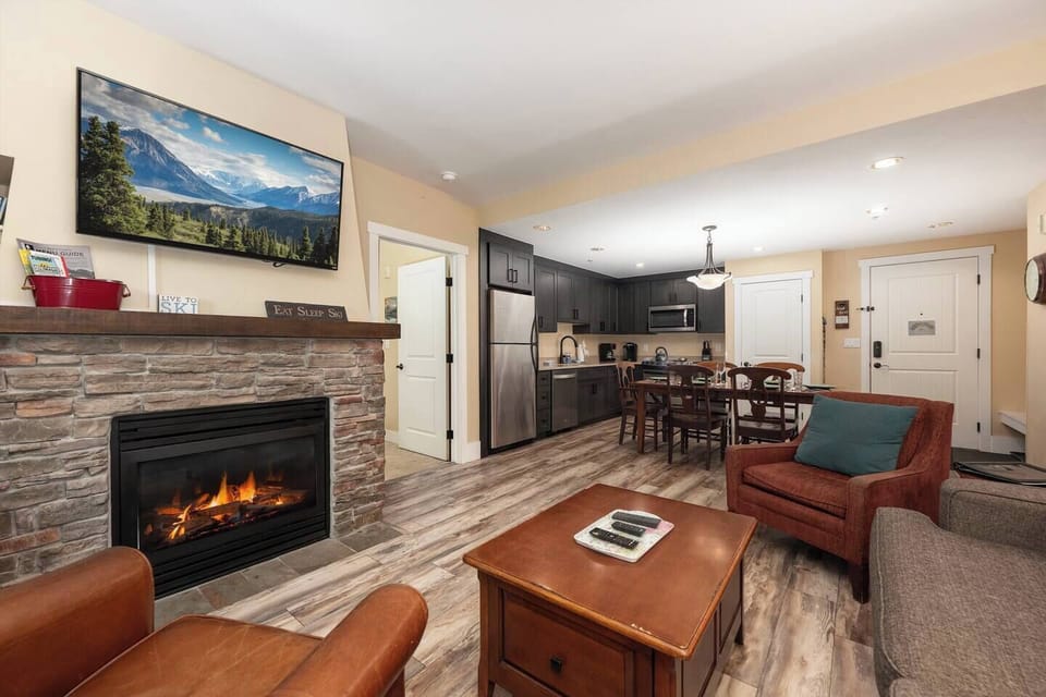 Open concept kitchen, dining and living area with gas fireplace, flat screen TV, pull-out sofa and views of the slope