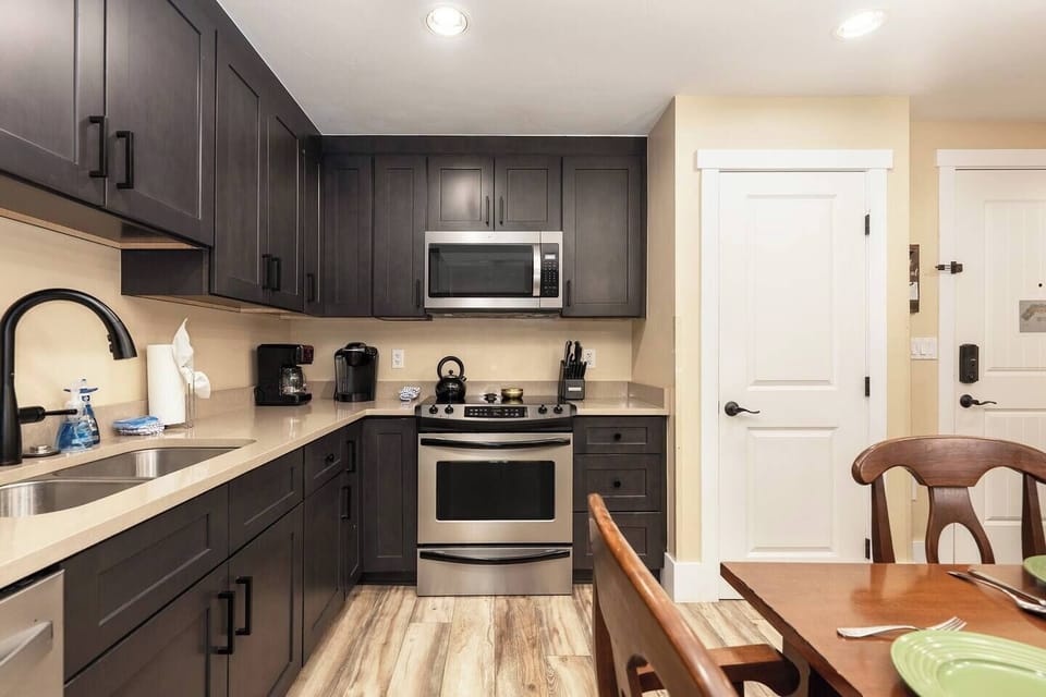 Open concept kitchen, dining and living area with gas fireplace, flat screen TV, pull-out sofa and views of the slope