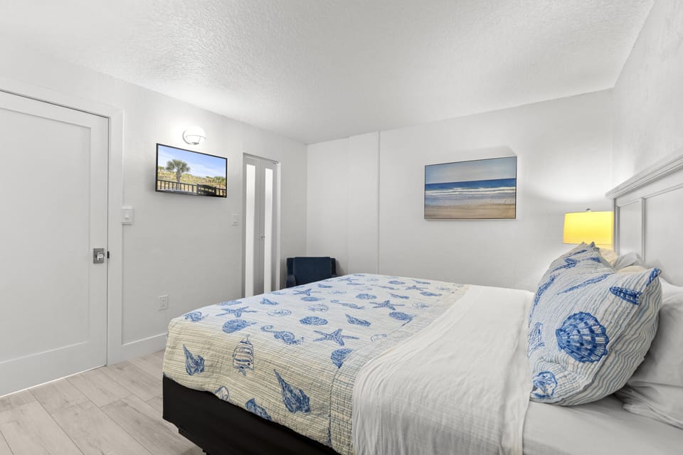 Third bedroom retreat with calming coastal decor, 32 inch smart TV and a comfy chair for reading