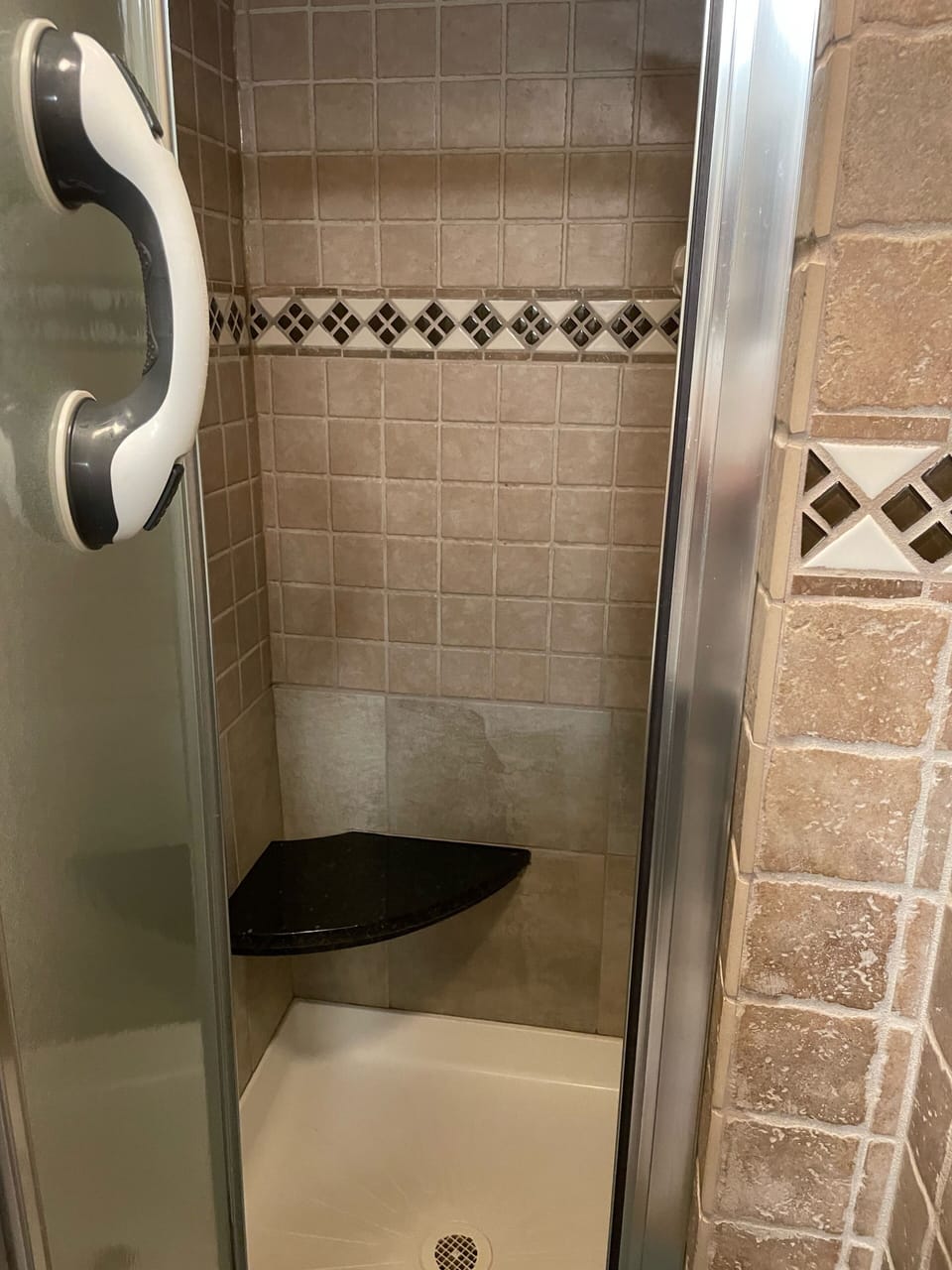 Shower with granite bench and grab bar.