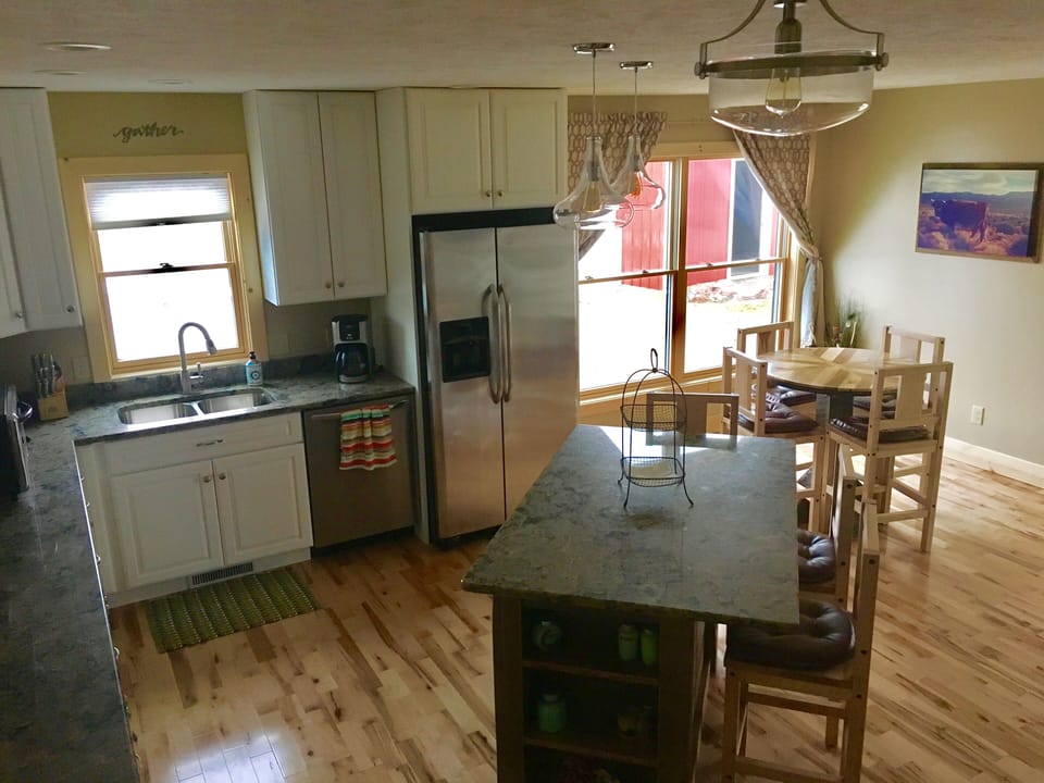 Kitchen with quartz countertops and barn wood island with seating for three. 