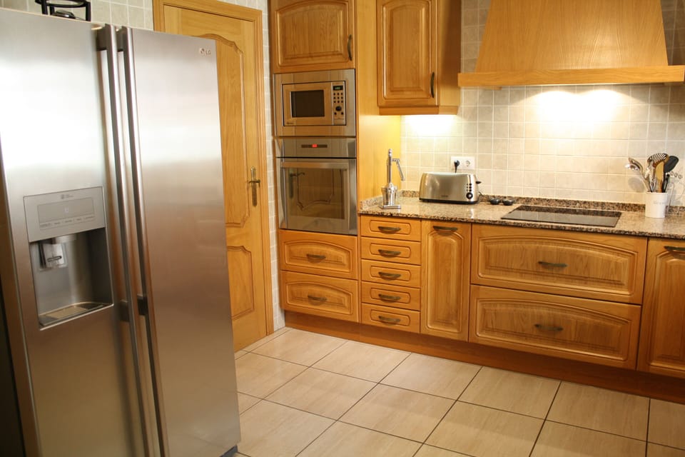 Well equipped kitchen with large American style freezer.
