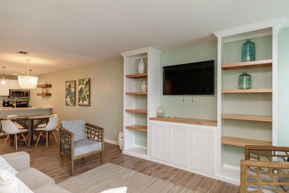 Unwind in your stylish open living space with custom built-ins, cozy seating, and seamless flow to the modern kitchen.
