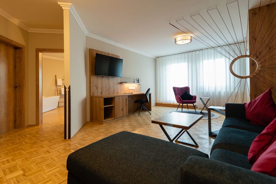 Deluxe Suite | Living area | 50-cm flat-screen TV with satellite channels, TV