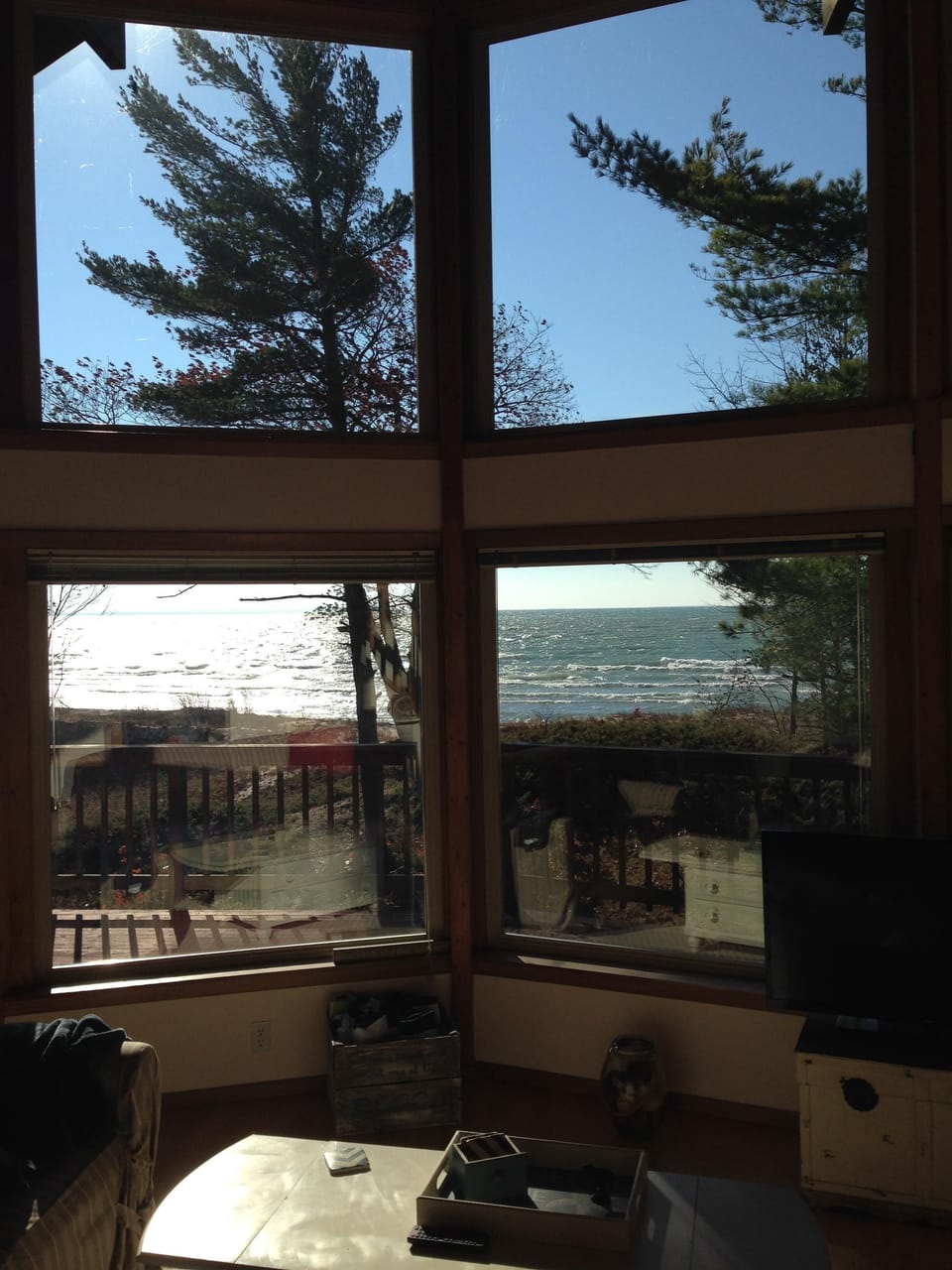 Large lakefront windows provide a stunning view of the lake in a natural setting