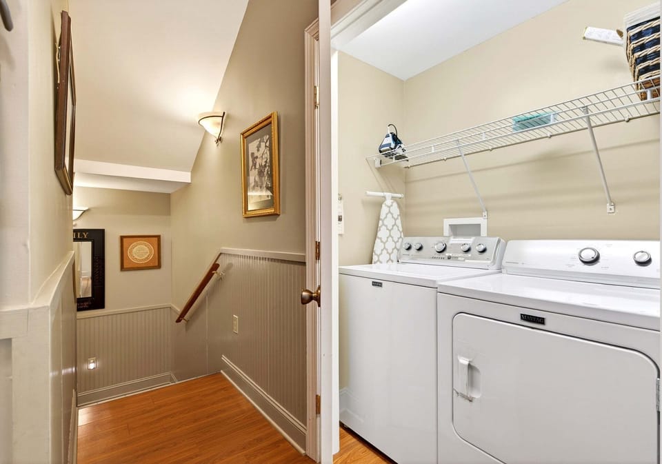 Laundry area with washer & dryer by the stairs leading to upper-level bedrooms.