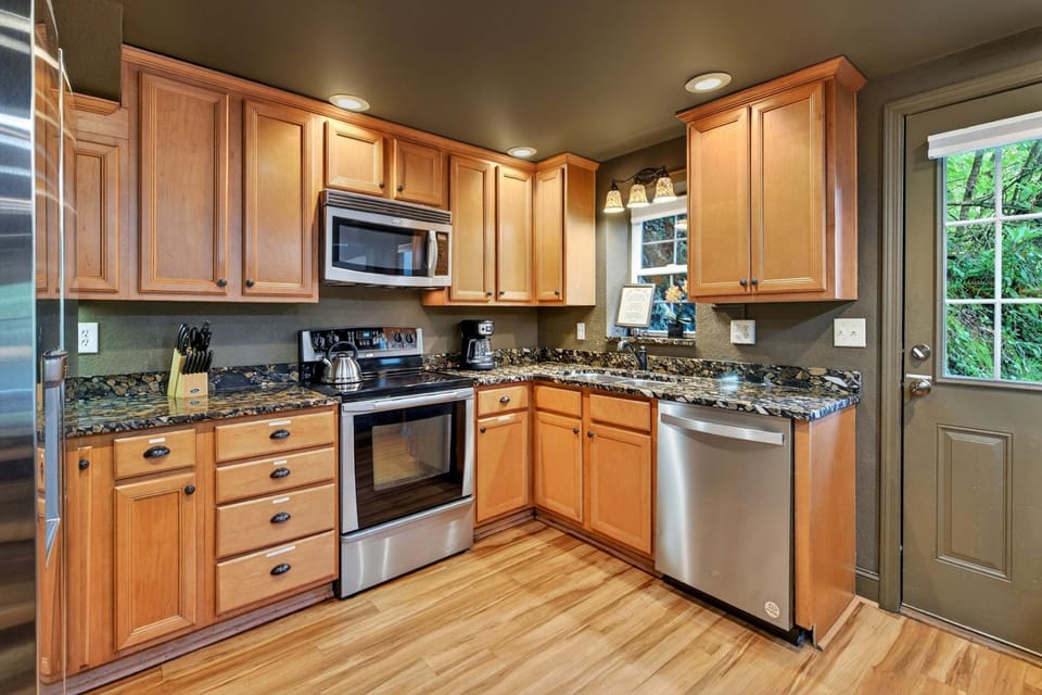 Updated galley-style kitchen with stainless steel appliances, a dishwasher, and two drip-style coffeemakers.